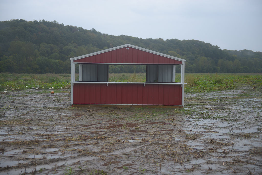 A produce stand sits in the middle of muddy pumpkin patch after harvest in Hartsburg